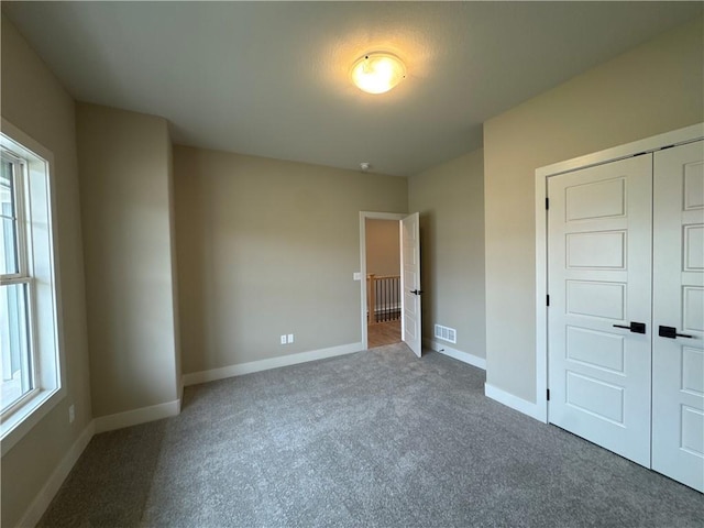 unfurnished bedroom with carpet floors and a closet