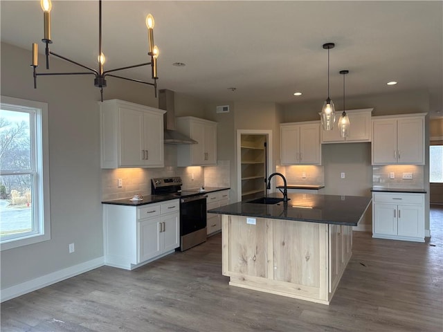 kitchen featuring sink, an island with sink, white cabinets, stainless steel electric range oven, and wall chimney exhaust hood