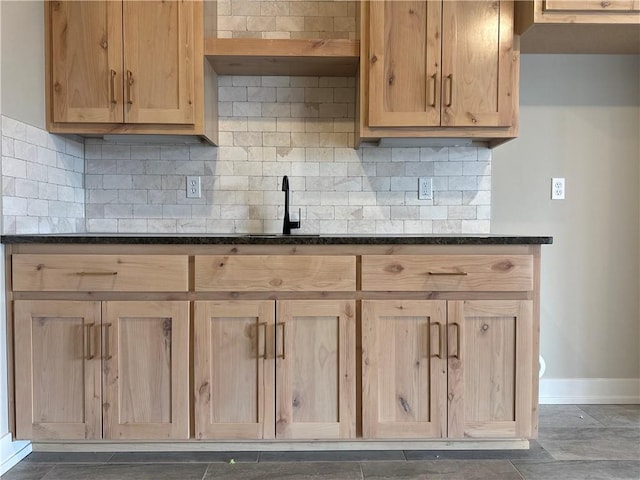 kitchen with sink, backsplash, and dark stone counters