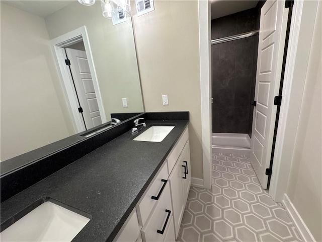 bathroom featuring vanity, a shower with shower door, and tile patterned floors