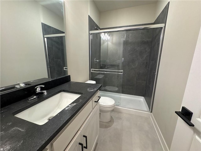 bathroom with vanity, toilet, and a shower with shower door