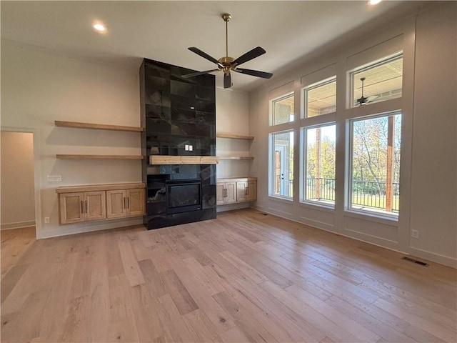 unfurnished living room featuring light wood-type flooring and ceiling fan