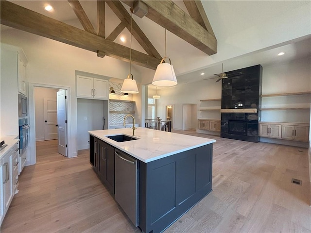 kitchen with white cabinetry, sink, appliances with stainless steel finishes, an island with sink, and pendant lighting