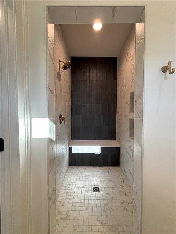 bathroom featuring tile patterned flooring and tiled shower