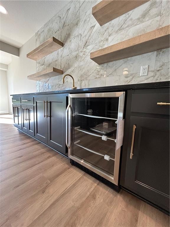 kitchen featuring light hardwood / wood-style flooring, sink, and wine cooler