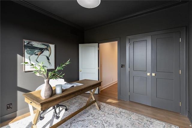 office area with crown molding and light wood-type flooring