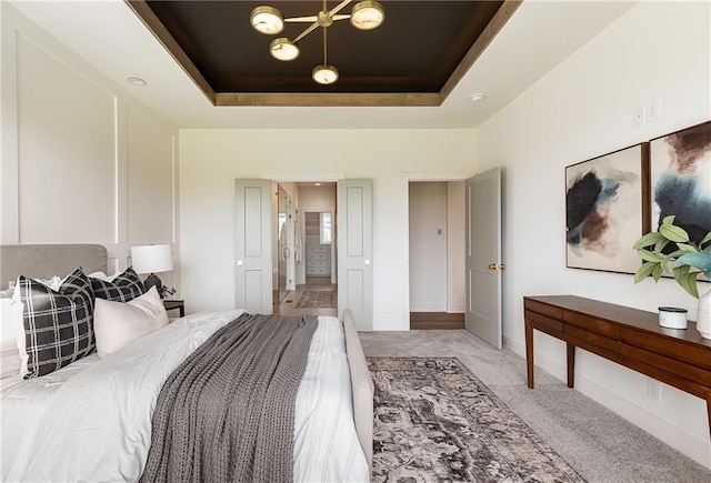 bedroom featuring light carpet and a raised ceiling