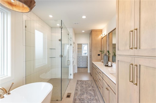 bathroom featuring vanity, independent shower and bath, and tile patterned floors