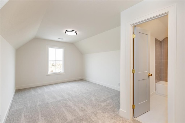 bonus room featuring light carpet and vaulted ceiling