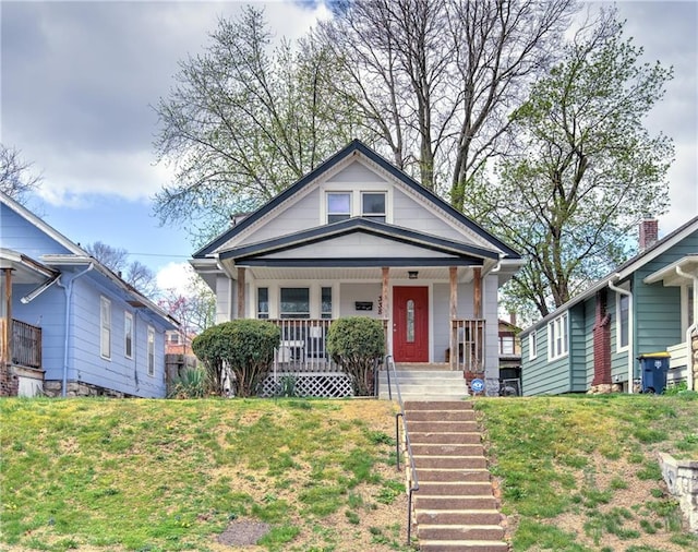 bungalow-style house with covered porch and a front lawn