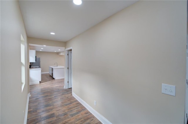 corridor featuring dark wood-type flooring and sink