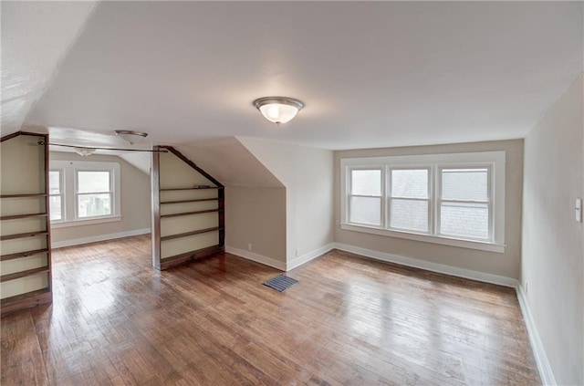 bonus room with vaulted ceiling and dark hardwood / wood-style flooring