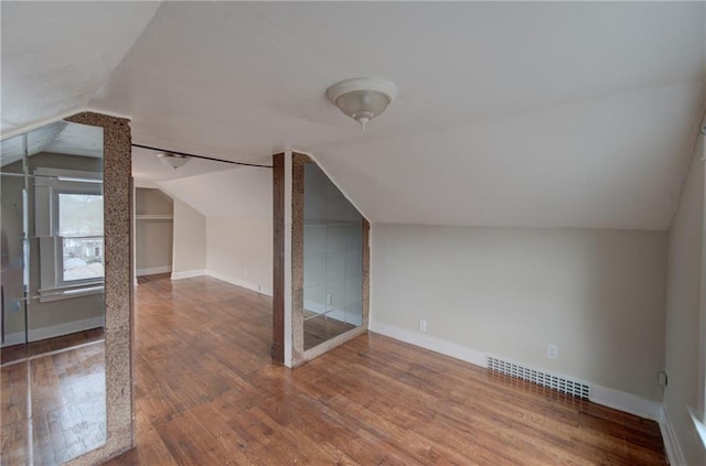 bonus room featuring dark wood-type flooring and lofted ceiling