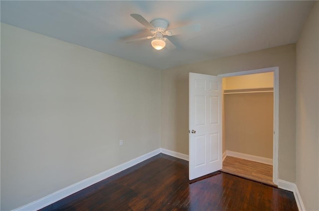 unfurnished bedroom with ceiling fan, dark hardwood / wood-style floors, and a closet