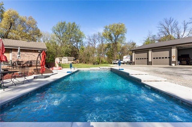 view of swimming pool featuring a storage unit, a patio, and a garage