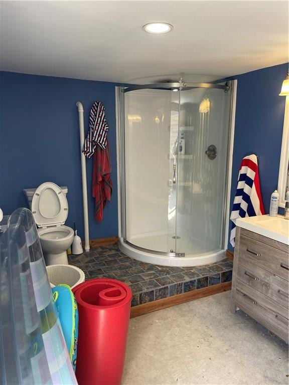 bathroom with vanity, a shower with door, and toilet