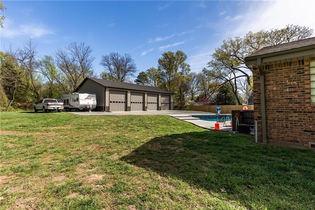 view of yard with an outbuilding, a garage, and a fenced in pool