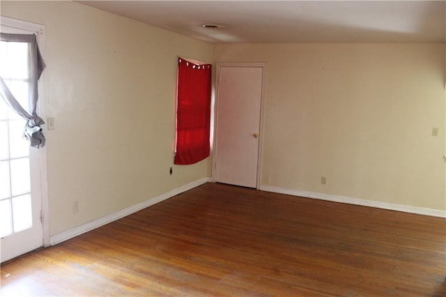 unfurnished room featuring plenty of natural light and hardwood / wood-style floors