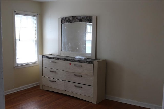 unfurnished bedroom featuring multiple windows and dark hardwood / wood-style floors