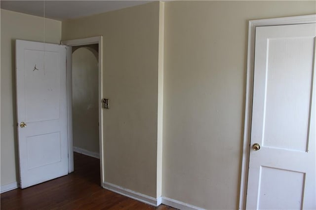 unfurnished bedroom with dark wood-type flooring