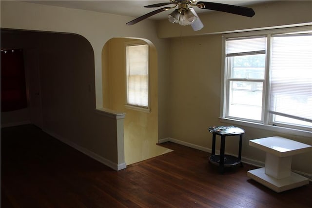 empty room with dark hardwood / wood-style flooring and a wealth of natural light