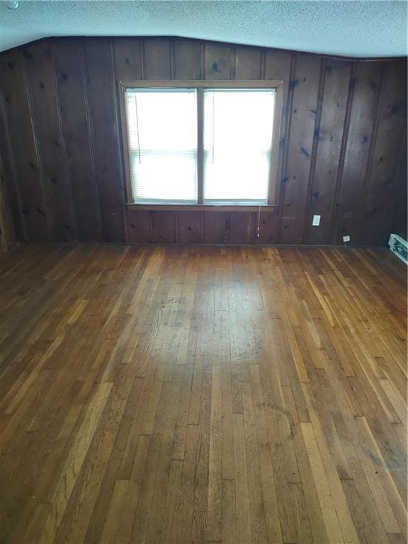 spare room featuring dark hardwood / wood-style floors and a textured ceiling