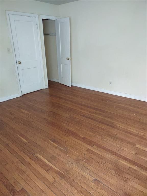 unfurnished bedroom featuring hardwood / wood-style flooring and a closet