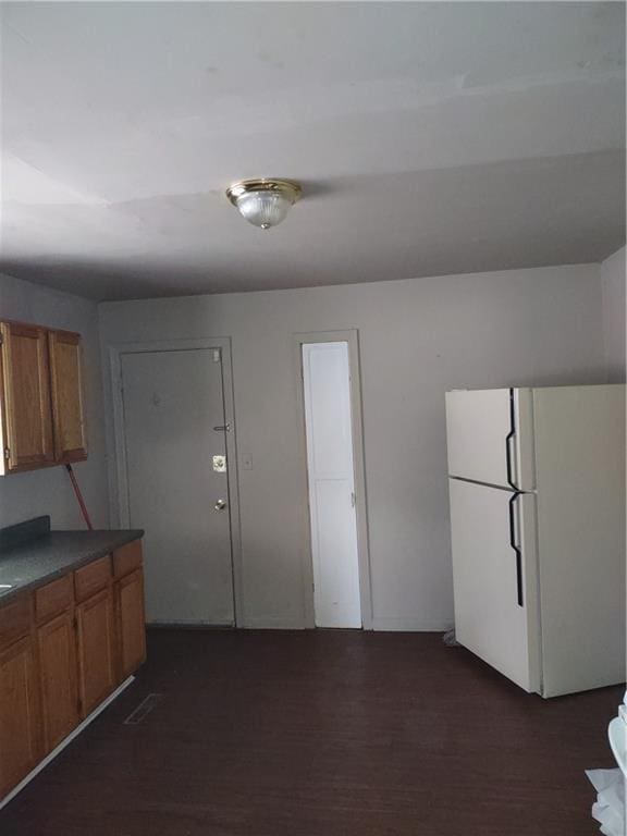 kitchen featuring white refrigerator and dark wood-type flooring