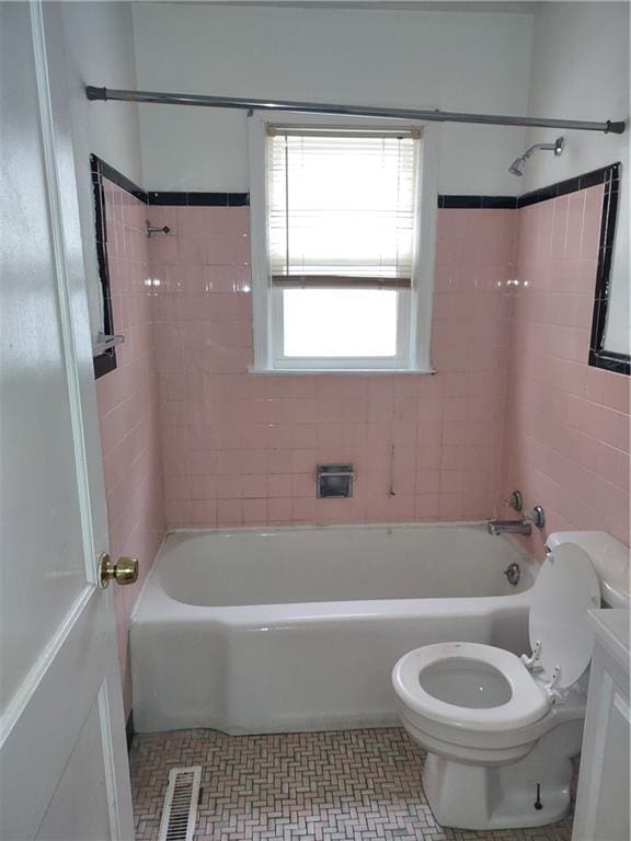 full bathroom featuring tiled shower / bath combo, vanity, tile patterned floors, and toilet