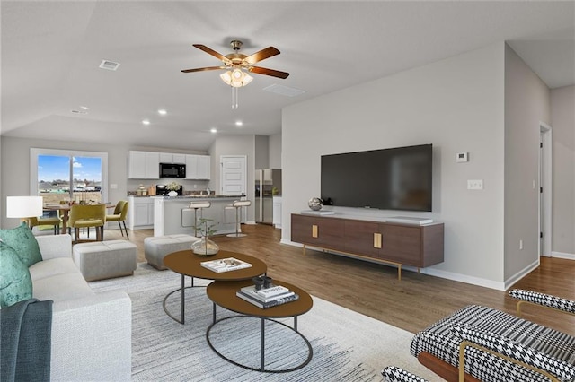 living room with ceiling fan and hardwood / wood-style flooring