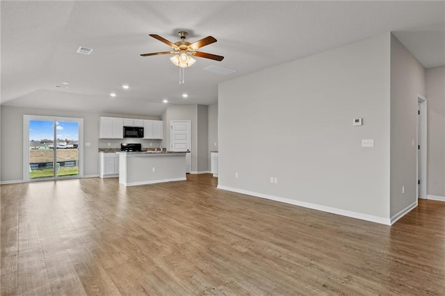 unfurnished living room with ceiling fan, light hardwood / wood-style flooring, and lofted ceiling