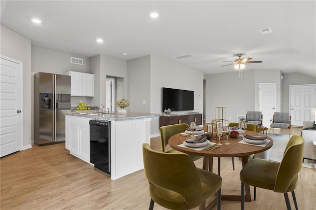 dining space with ceiling fan, light wood-type flooring, and sink