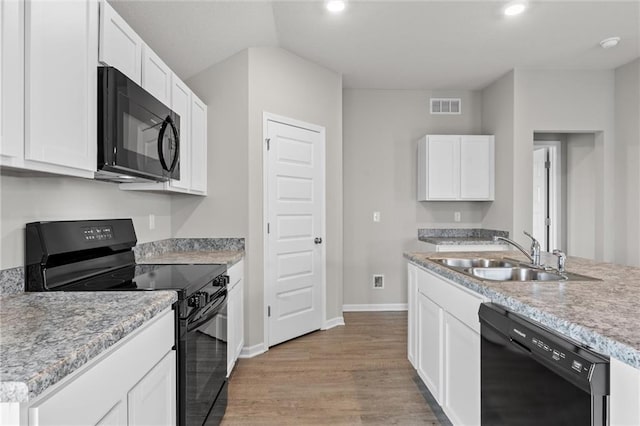 kitchen with black appliances, light hardwood / wood-style floors, white cabinets, and sink