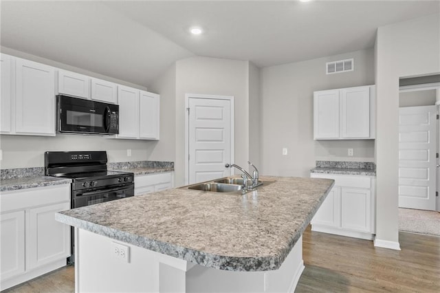 kitchen featuring black appliances, white cabinets, a center island with sink, and sink