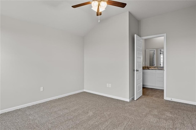 unfurnished bedroom featuring carpet floors, ensuite bathroom, ceiling fan, and lofted ceiling