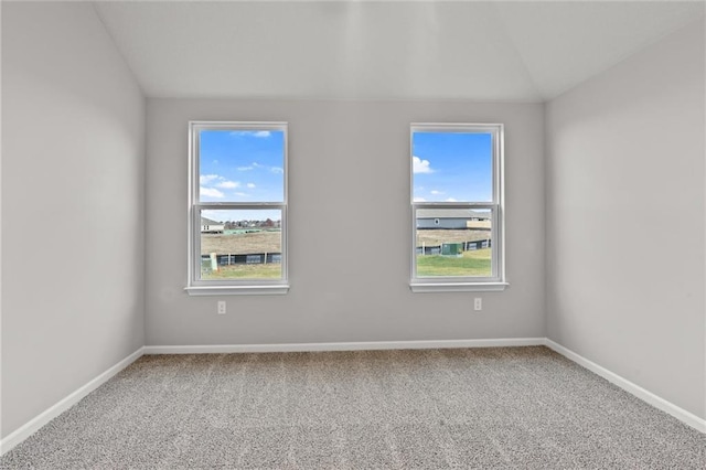 spare room with carpet flooring, vaulted ceiling, and a wealth of natural light