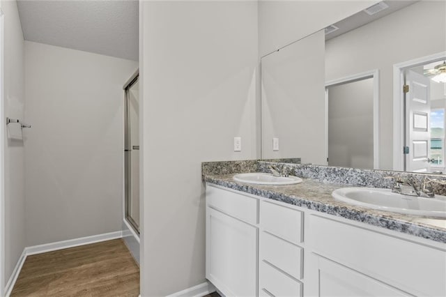 bathroom with vanity, a textured ceiling, hardwood / wood-style flooring, and a shower with door