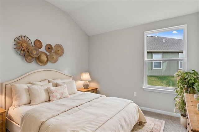 carpeted bedroom with lofted ceiling