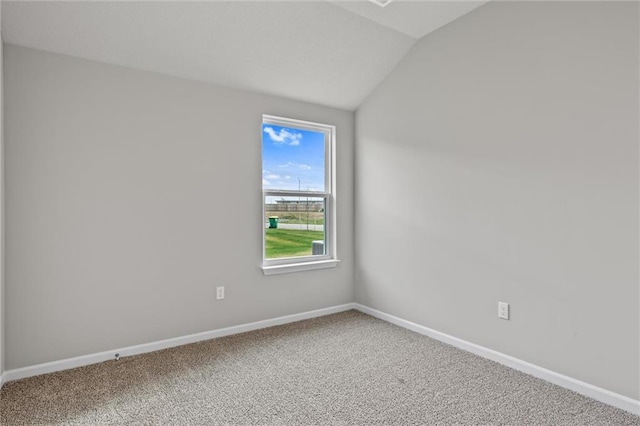 carpeted empty room with lofted ceiling