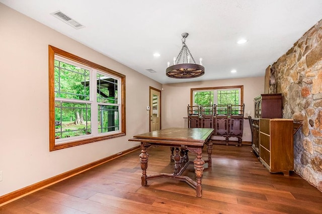 dining room with dark hardwood / wood-style flooring and a chandelier