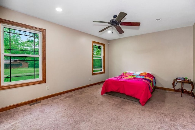 bedroom featuring carpet floors, multiple windows, and ceiling fan