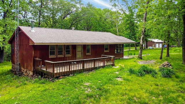 rear view of property with a yard and a wooden deck