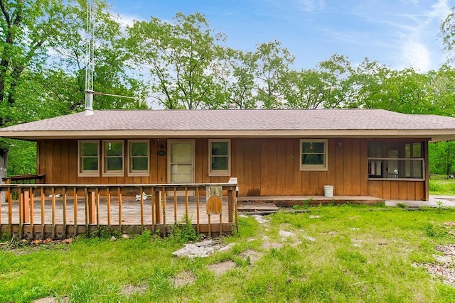 ranch-style home with a wooden deck and a front yard