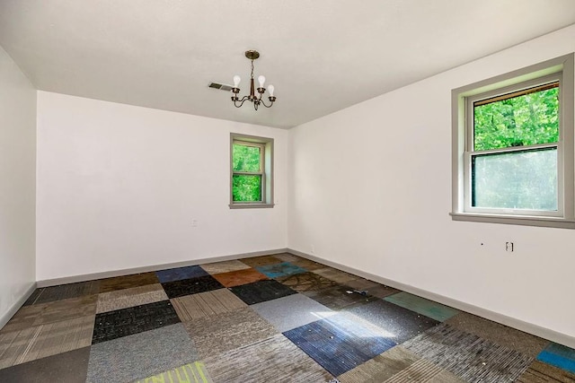 unfurnished room with an inviting chandelier