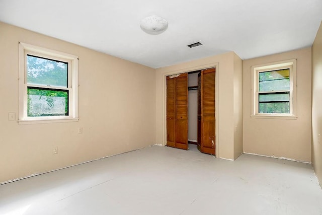 unfurnished bedroom with multiple windows and a closet