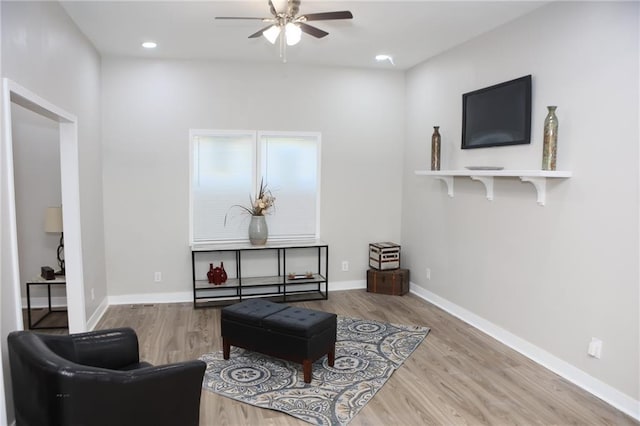 sitting room with hardwood / wood-style floors and ceiling fan