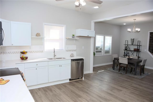 kitchen featuring backsplash, light hardwood / wood-style flooring, stainless steel appliances, ceiling fan with notable chandelier, and white cabinetry