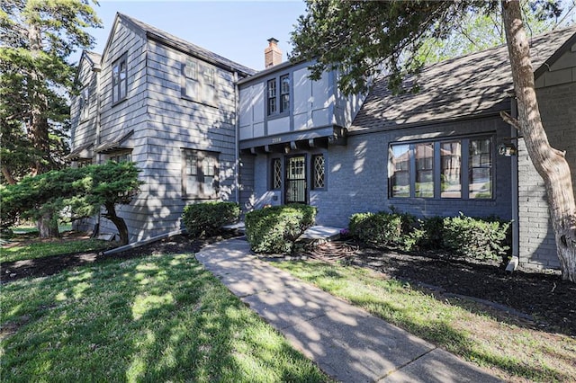 tudor home with a front lawn