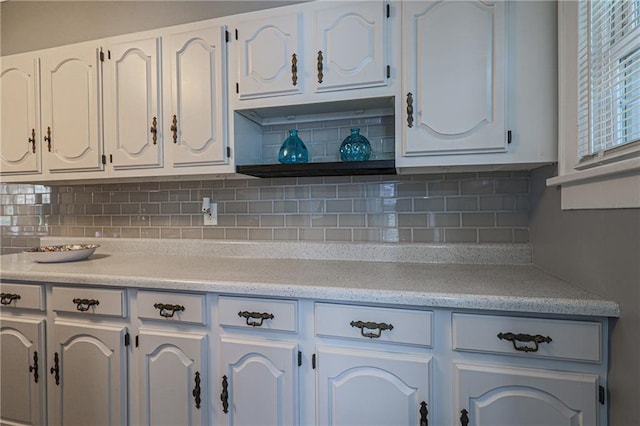 kitchen with backsplash and white cabinetry