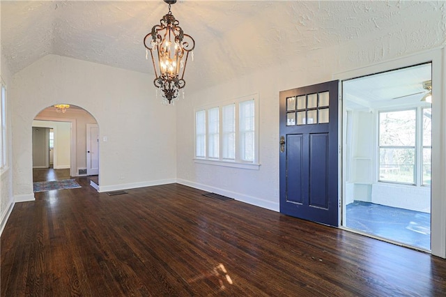 entryway featuring lofted ceiling, a textured ceiling, dark wood-type flooring, and ceiling fan with notable chandelier